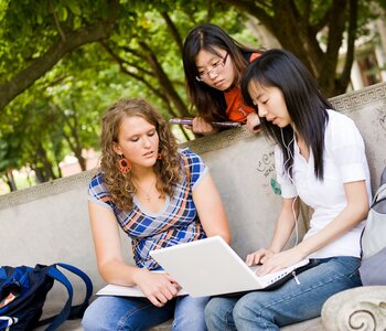 Students talking underneath "Eternal Flame" on UI Quad.