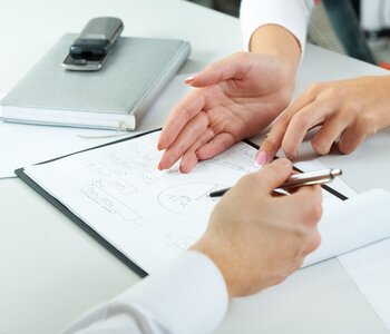 Close up of hands and paperwork at meeting