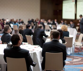 People seated at indoor conference 